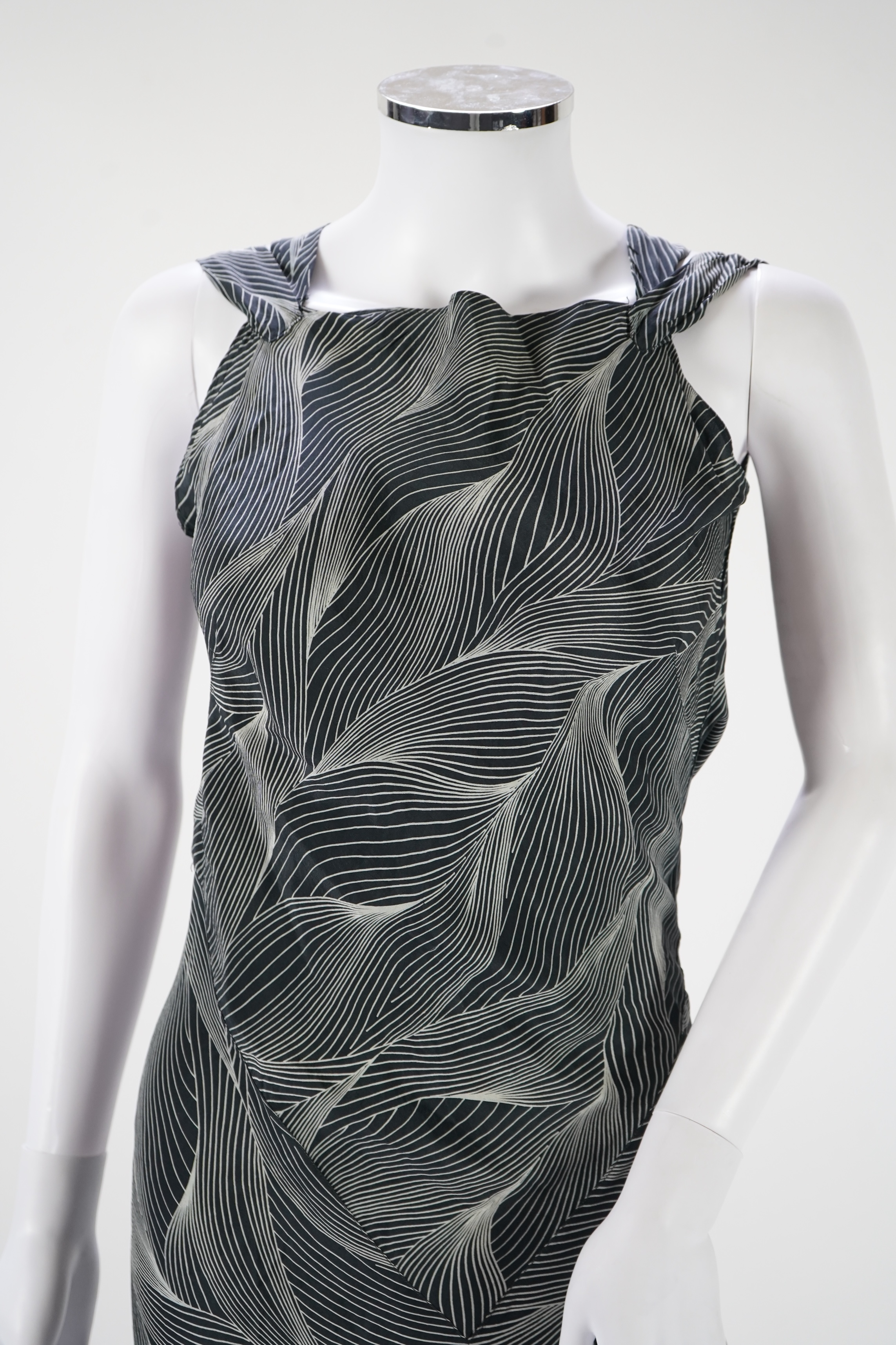 A 1930's black and silver halter neck, bias cut, ladies silk evening dress, designed with a loosely falling back and frills falling from the back of the dress to the front, bust bias cut 32-36 inches, length 57 inches fr